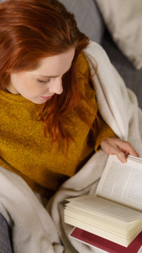 Entspannte frau liest ein buch auf der couch